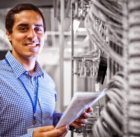 Portrait of technician analyzing server in server room